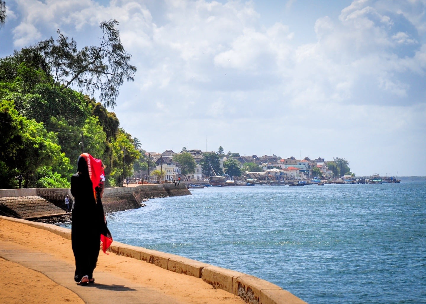 woman walking Corniche Path between Shela Lamu Old Town