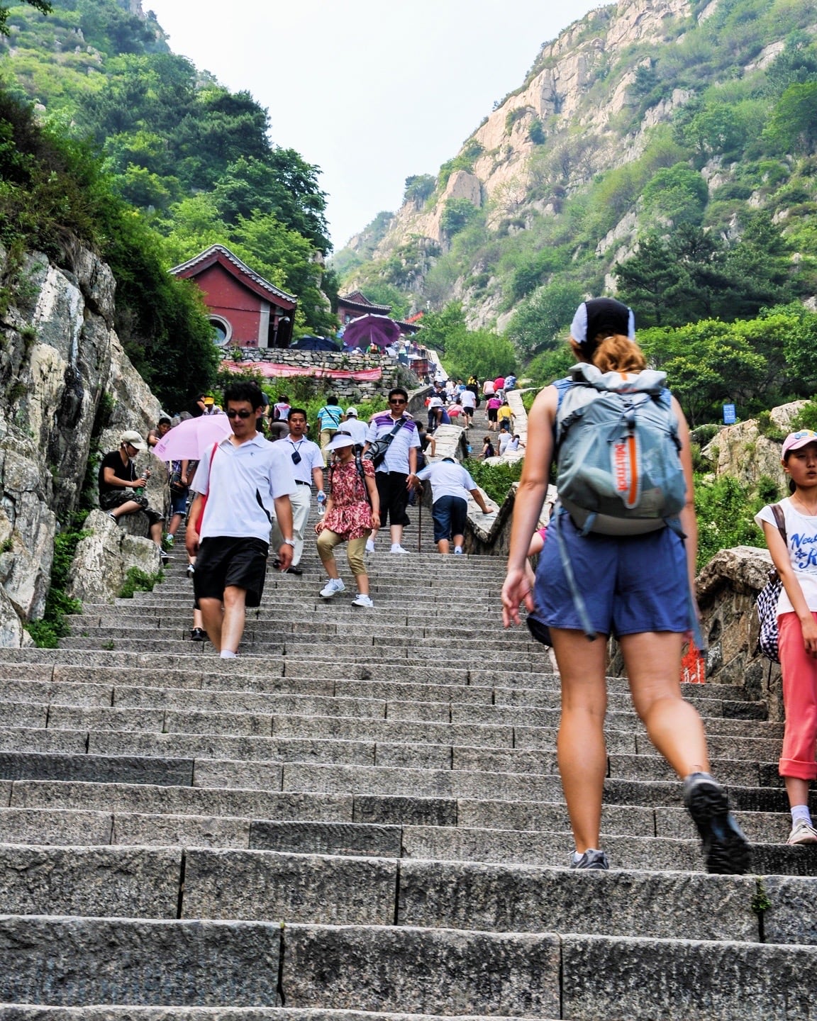 crowds climbing long set of stairs on a mountain