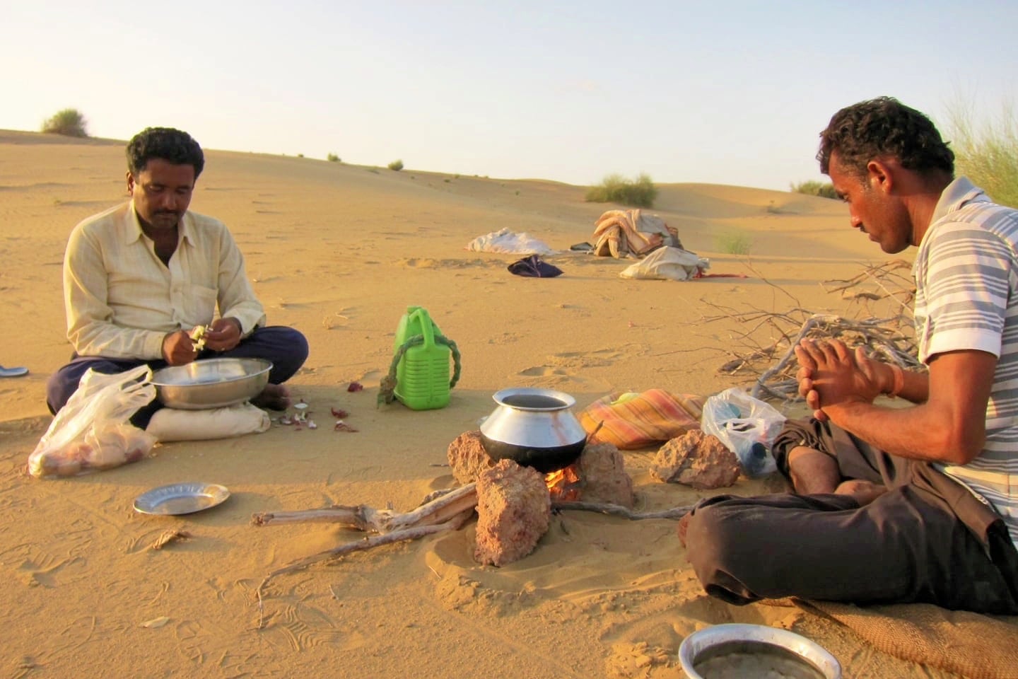 men preparing a meal on the Khuri sand dunes