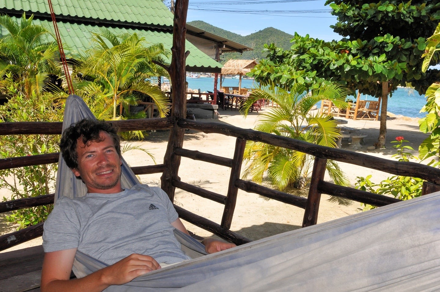 man swinging on hammock near beach