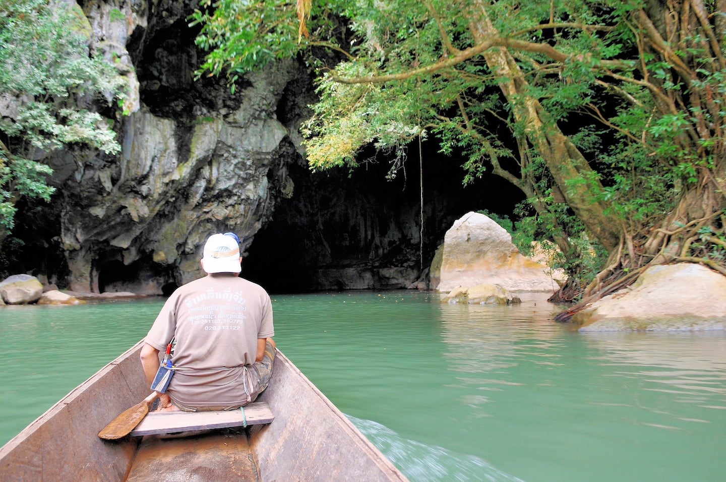 man on boat near water cave