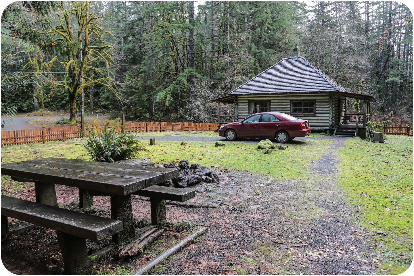 car in front of rustic log cabin in Washington State