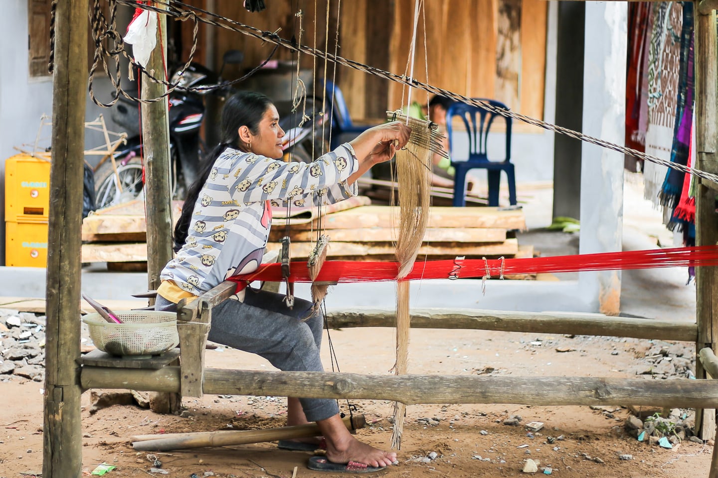 Laotian woman weaving under house in Sop Cham village