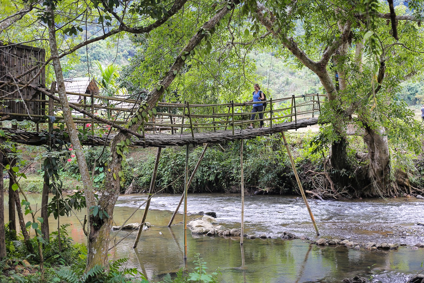 walking across log bridge Muang Ngoi Neua
