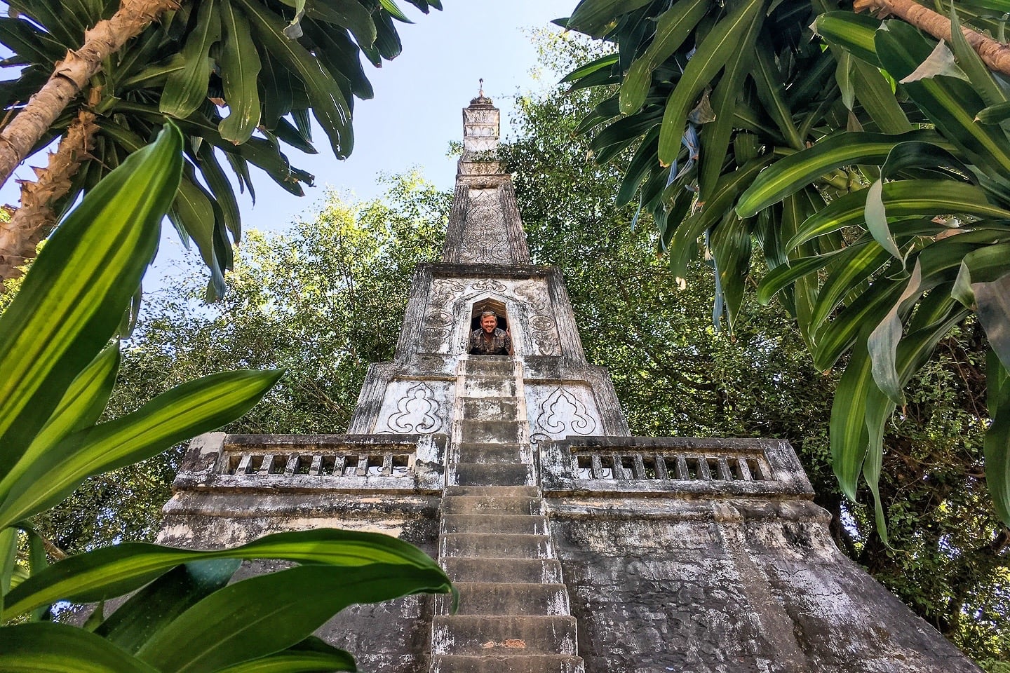 man peering out of temple sculpture