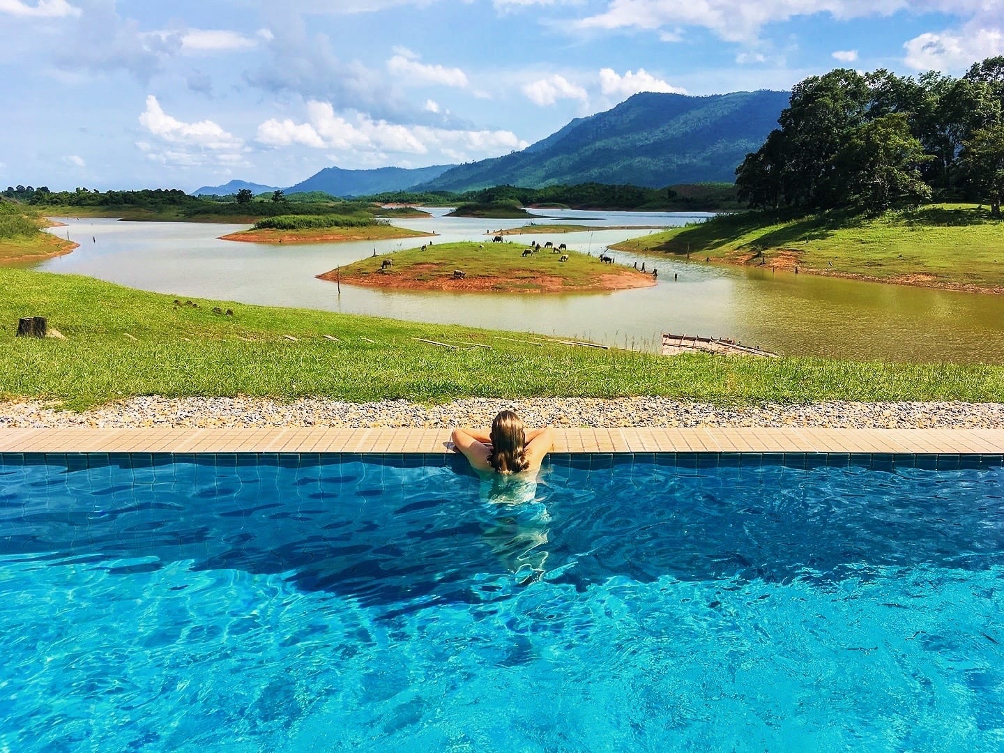 woman in pool overlooking lake