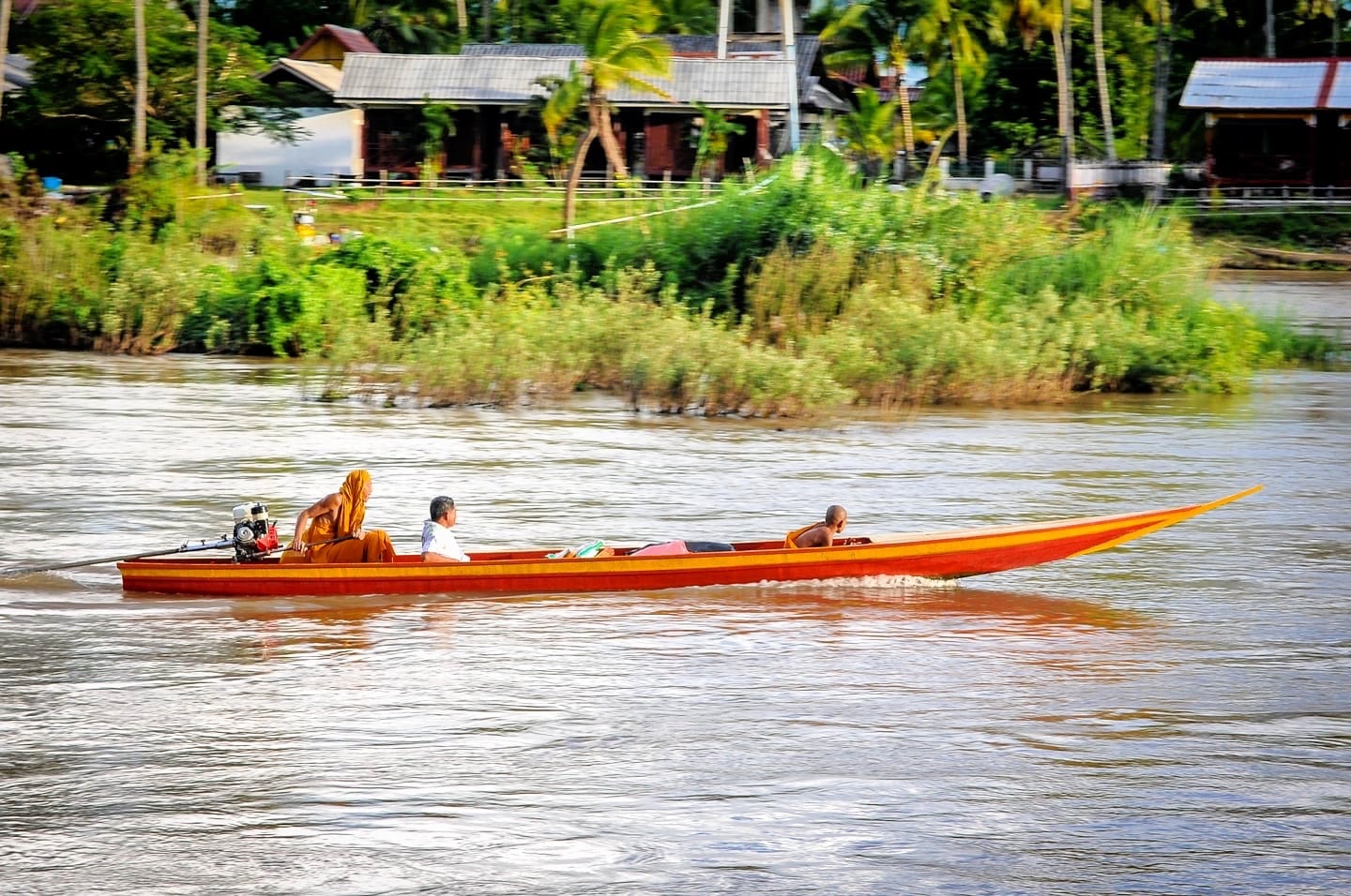 buddhist monk driving motorboat