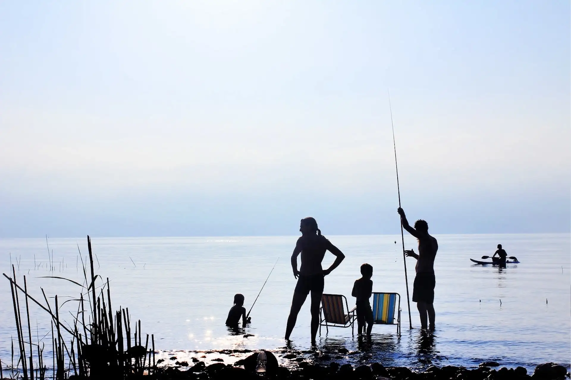 two people traveling with a toddler at a lake and fishing