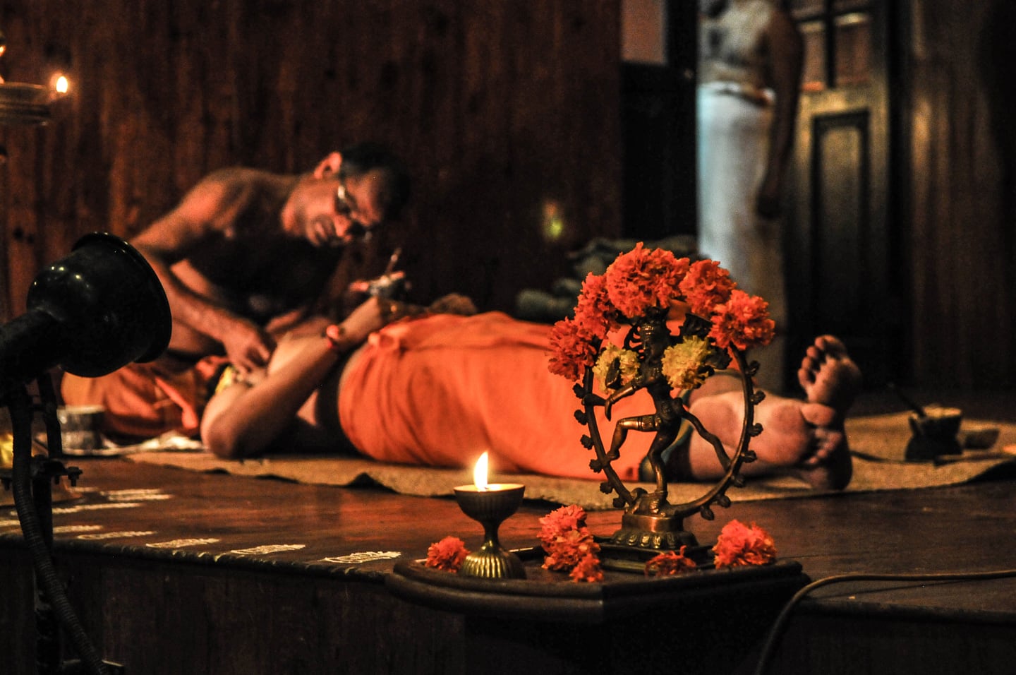 applying makeup to Kathakali dancer before show