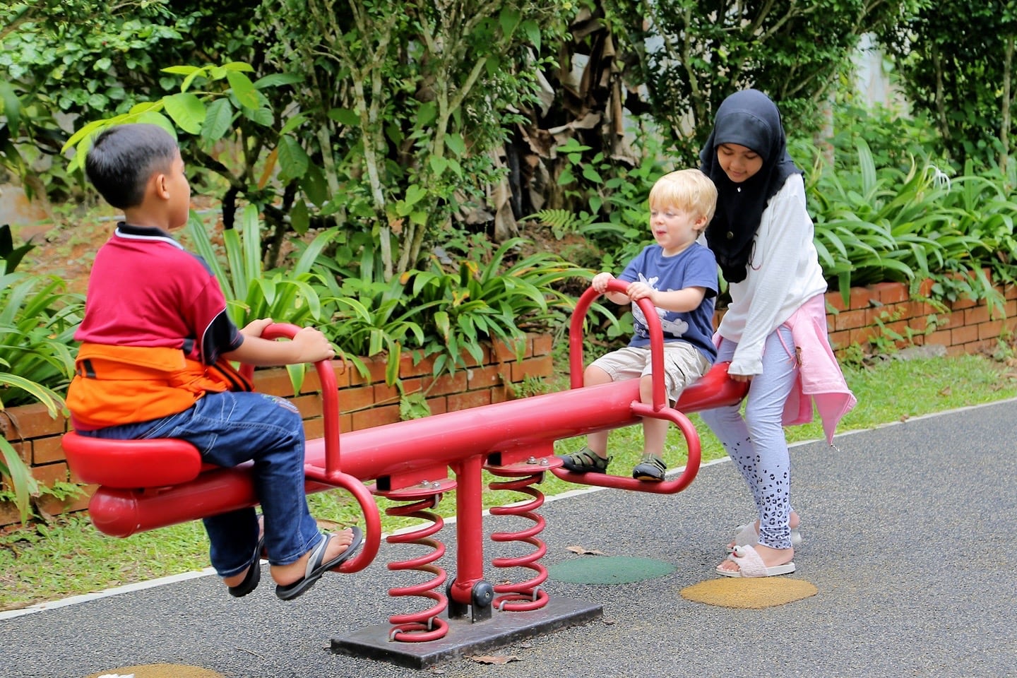 children playing on a teeter totter at a park