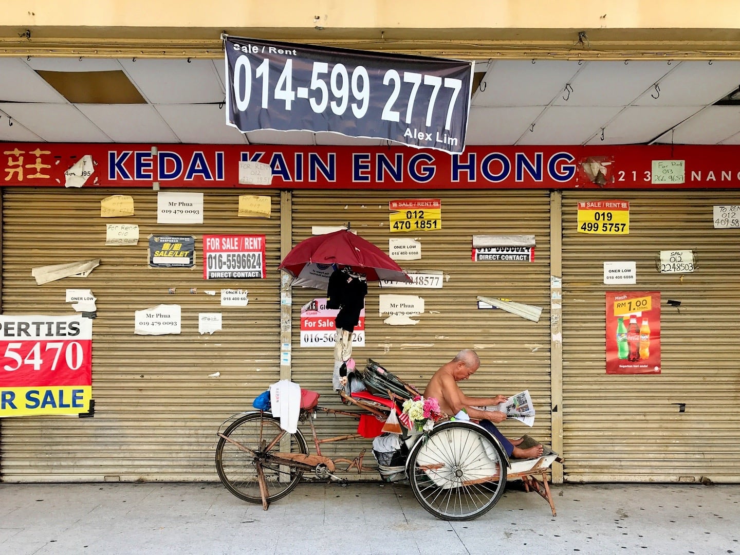 trishaw driver reading newspaper