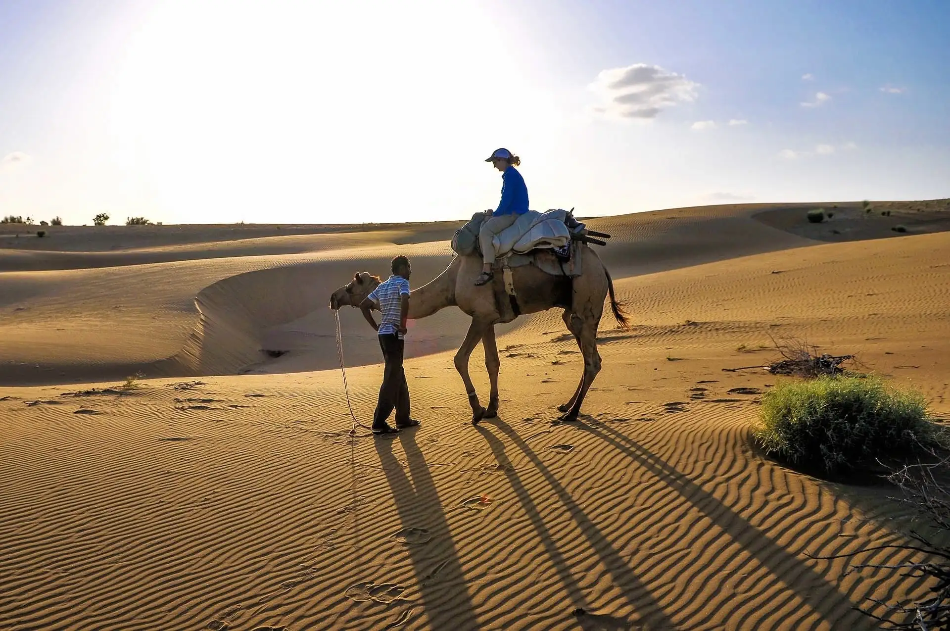 woman on camel with driver in Khuri Sand Dunes Jaisalmer Rajasthan India