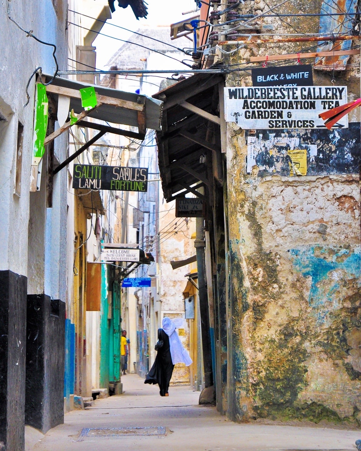 woman walking through alleys of Lamu Town Kenya