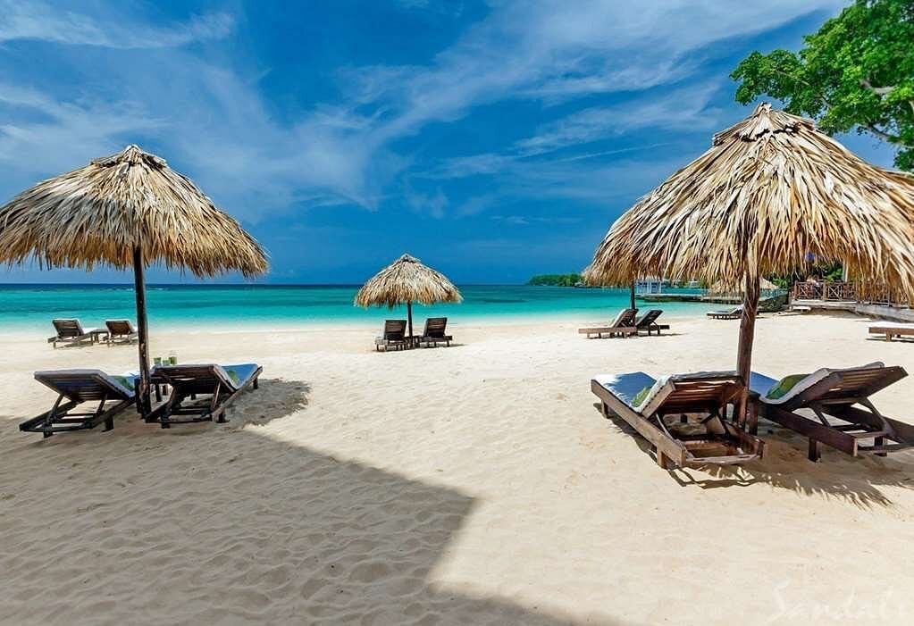 palapa umbrellas and beach chairs at Sandals Royal Plantation