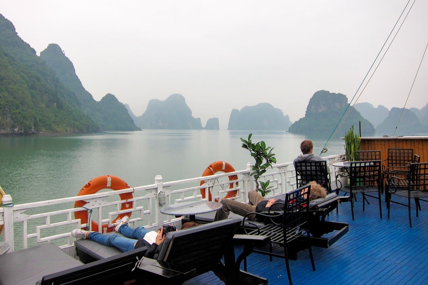 man relaxing on top deck of Halong Bay cruise boat