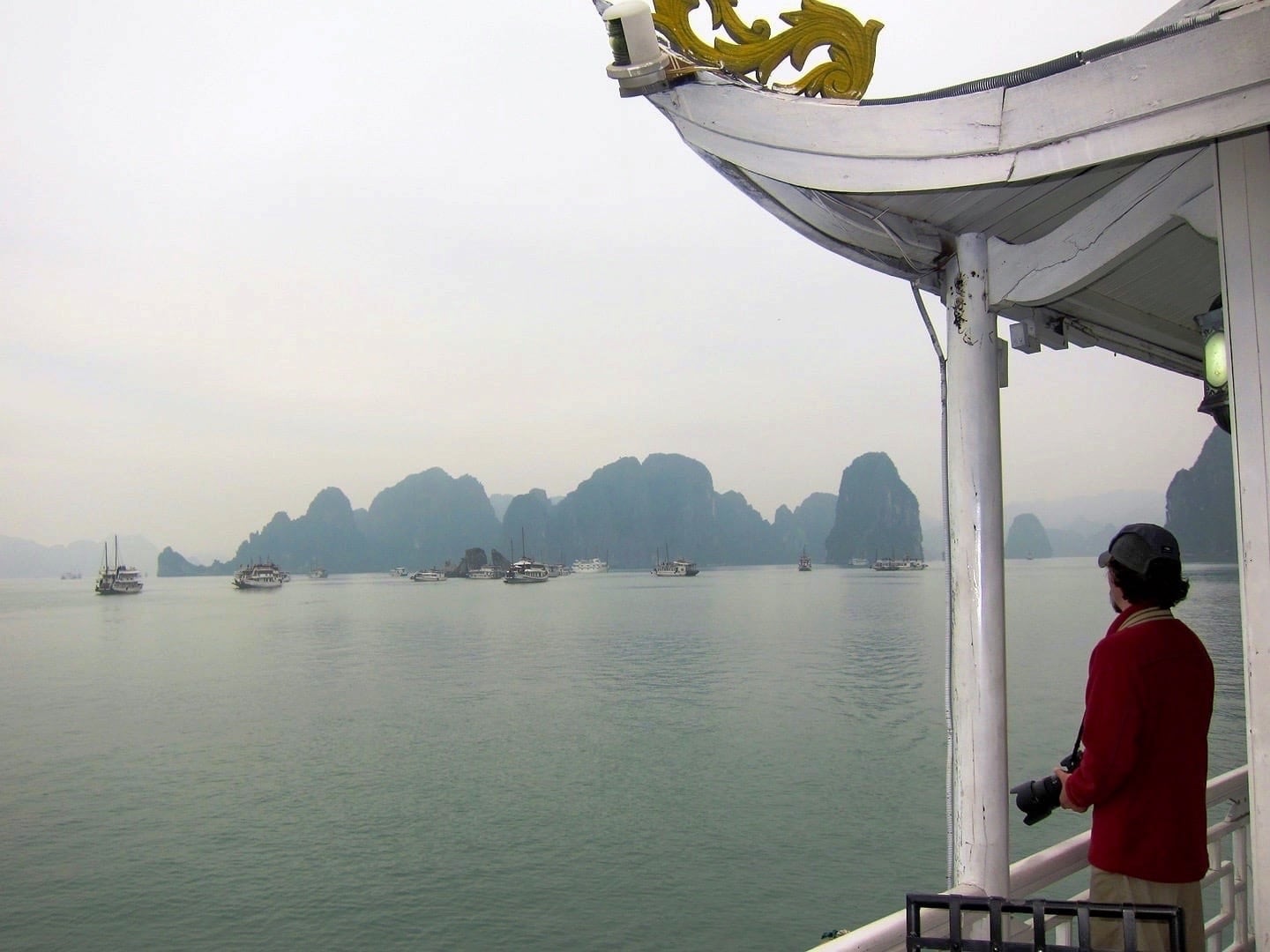 man looking out at water and karst formations Halong Bay cruise