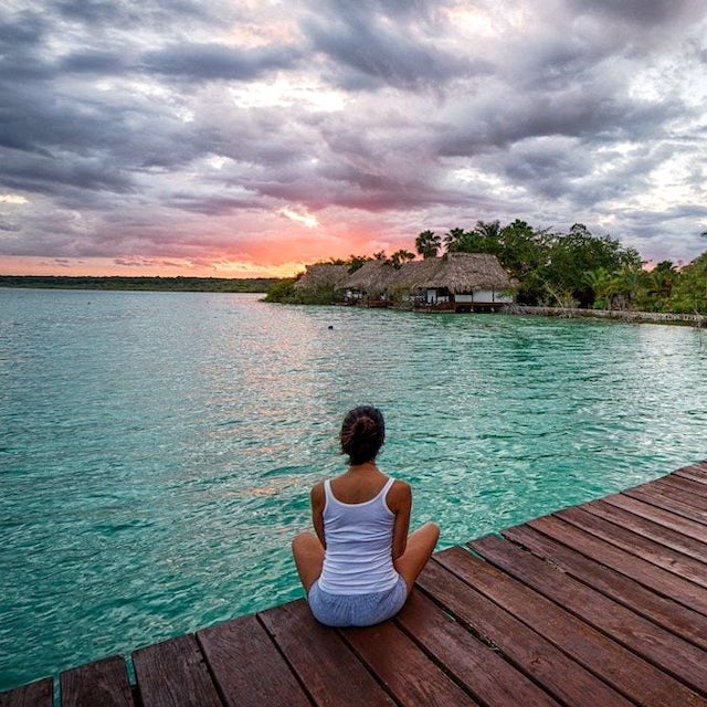 woman watching sunset over lagoon