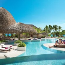 couple relaxing poolside at adults-only all-Inclusive Caribbean resorts