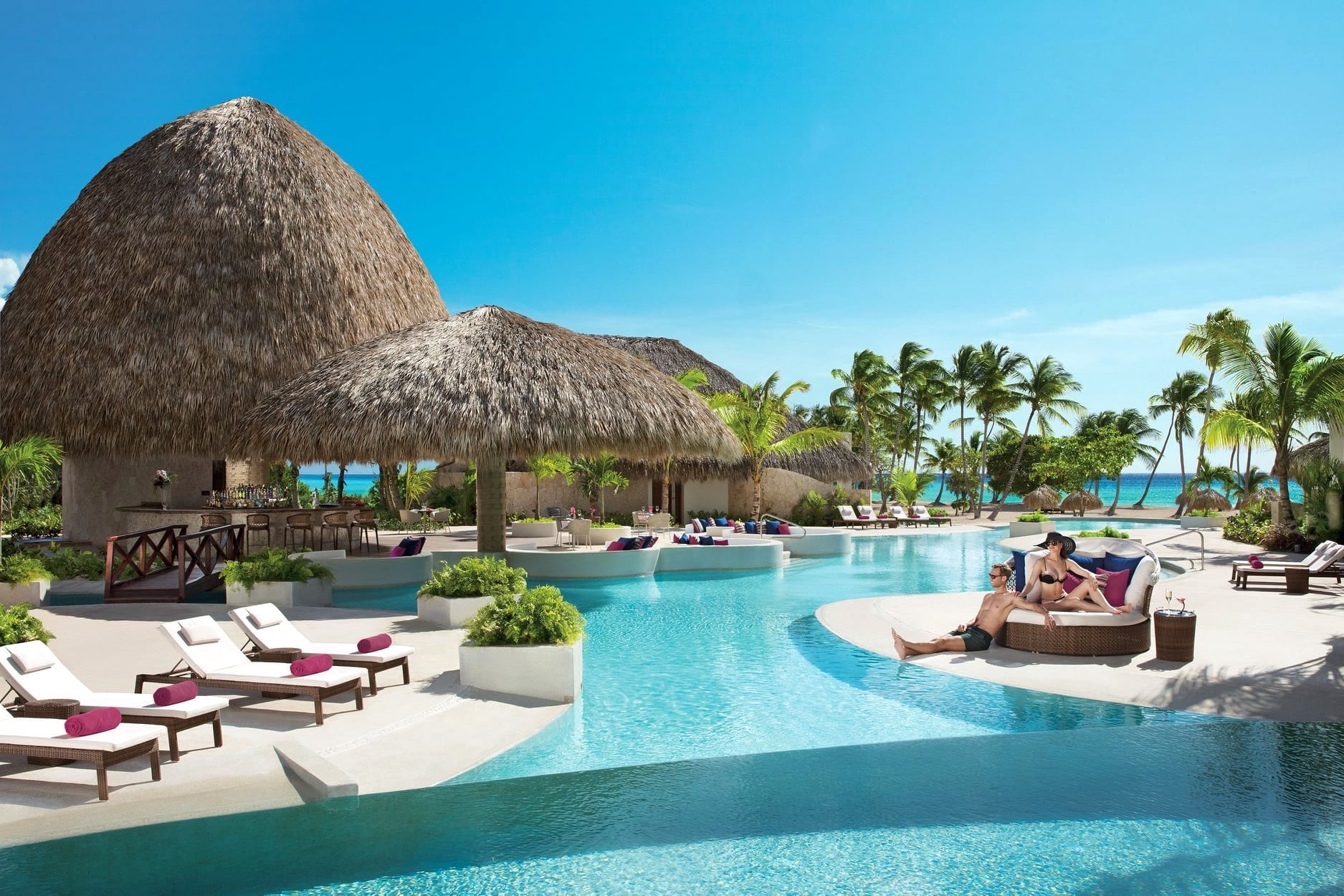 couple relaxing poolside at luxury adults only all inclusive Caribbean resorts