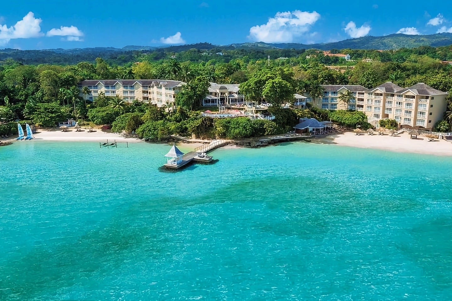 hotel fringed by lush forest and aquamarine water