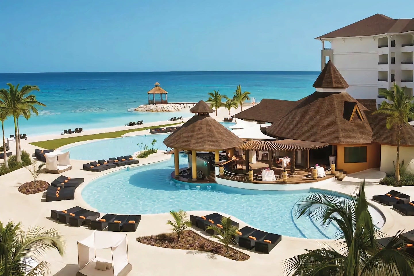 large pool overlooking blue sea at luxury hotel