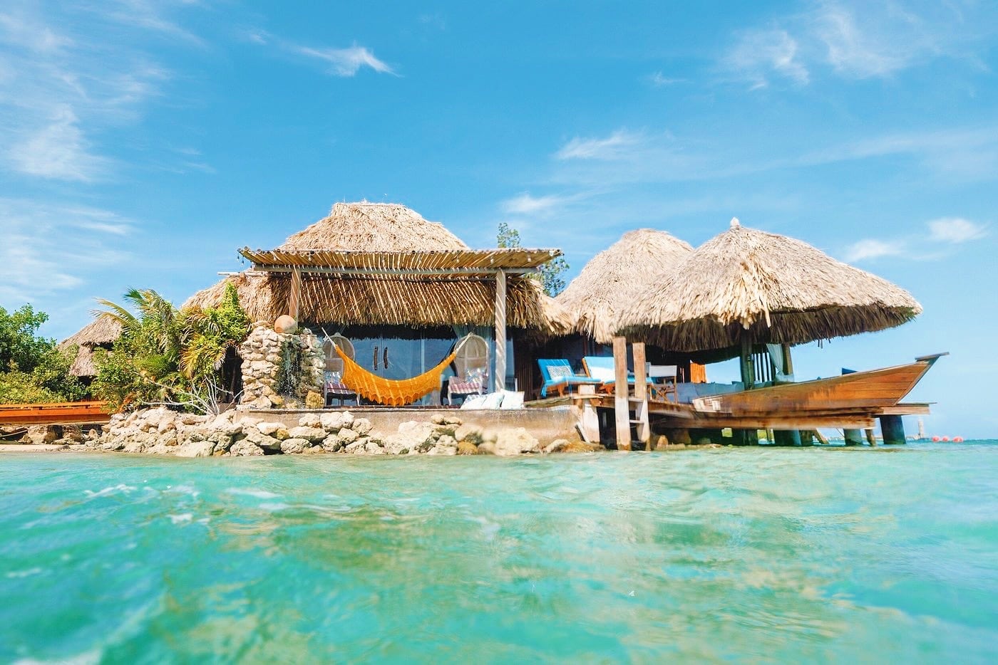 over the water bungalow with hammock and turquoise water in the Caribbean