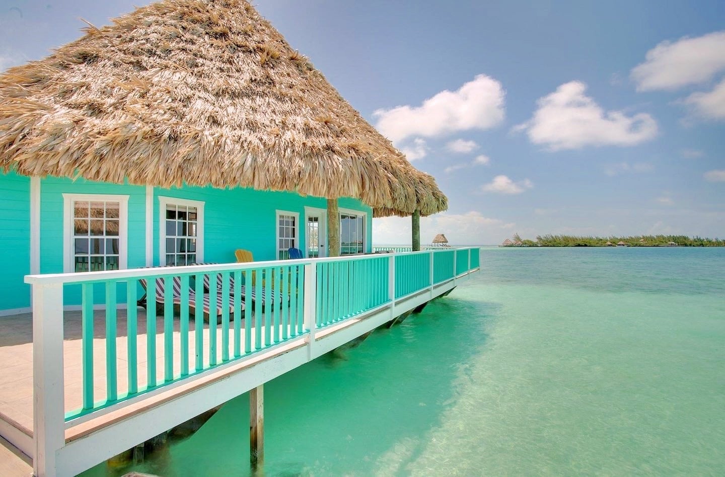 aqua colored water villa with thatch roof