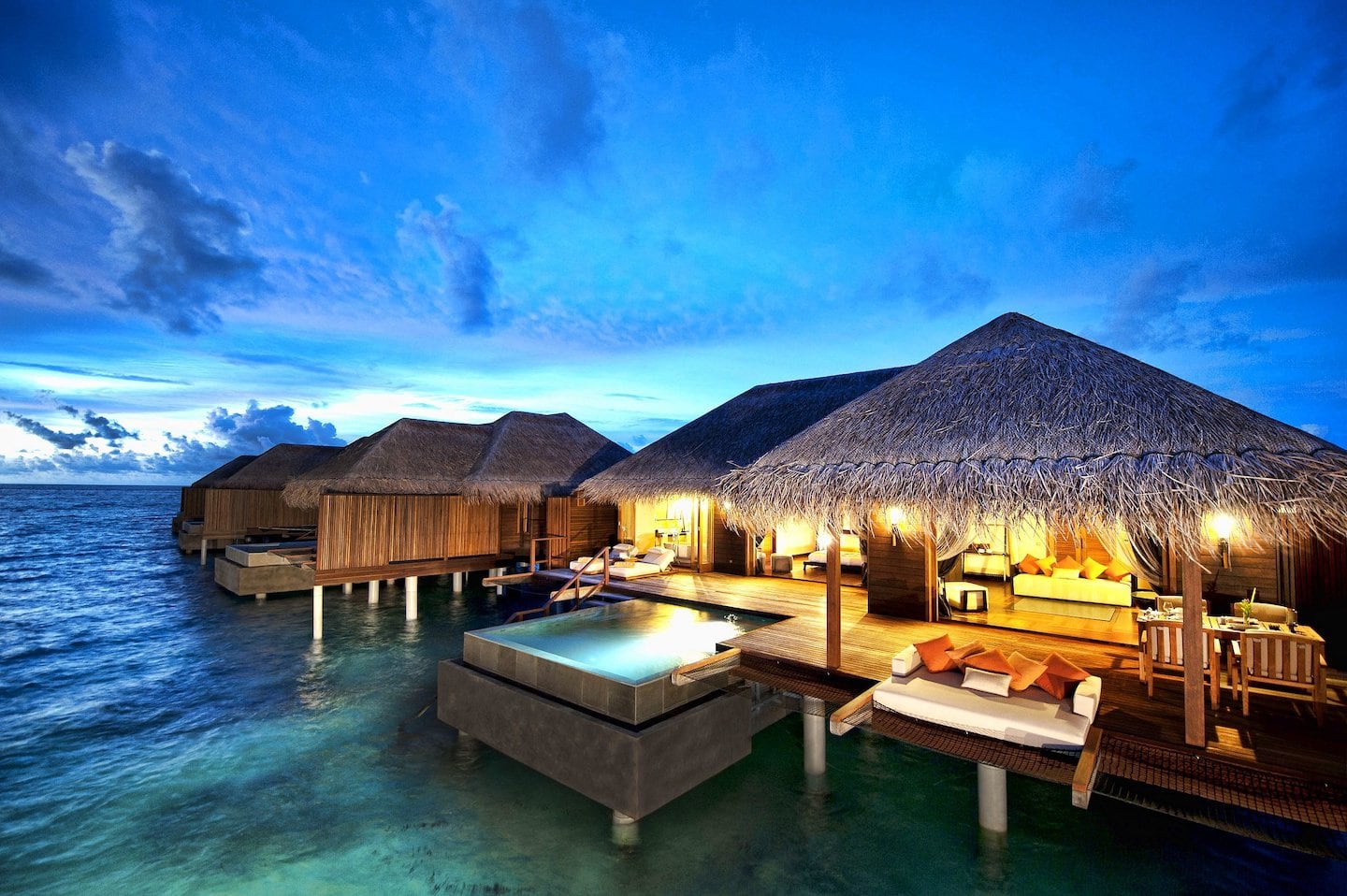 Caribbean overwater bungalow with pool at night