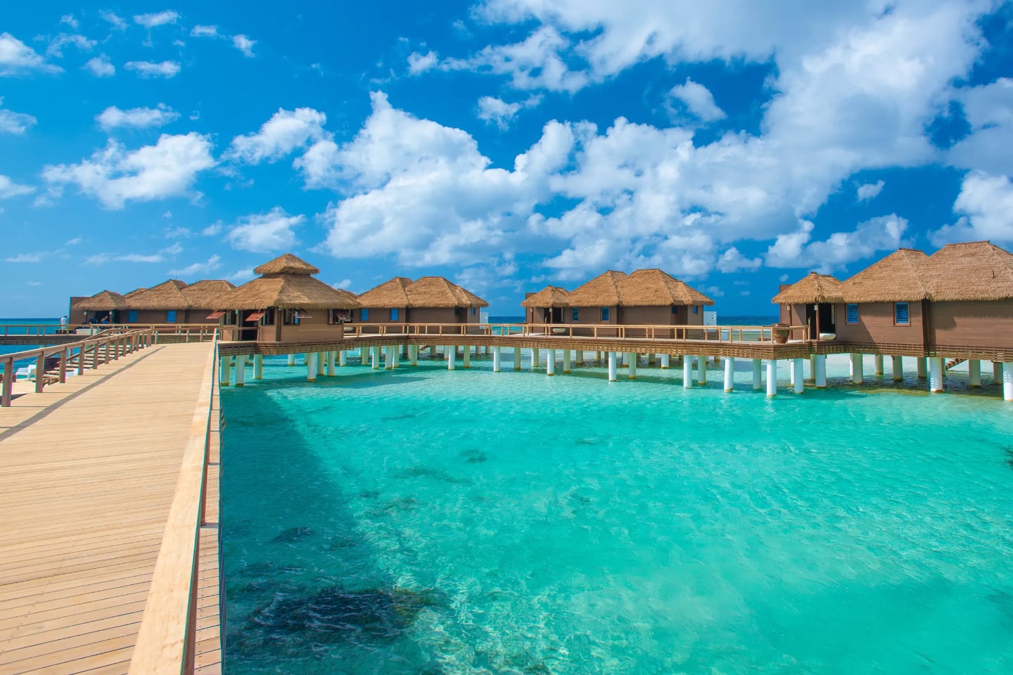 overwater bungalows over clear turquoise water in Jamaica