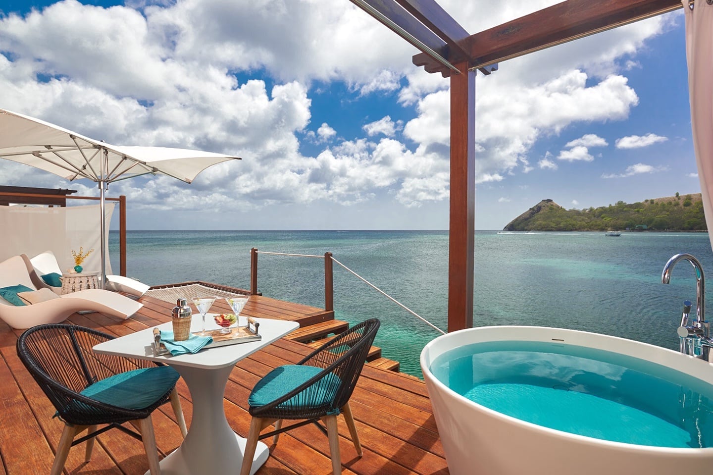 soaking tub and patio set on deck overlooking Caribbean