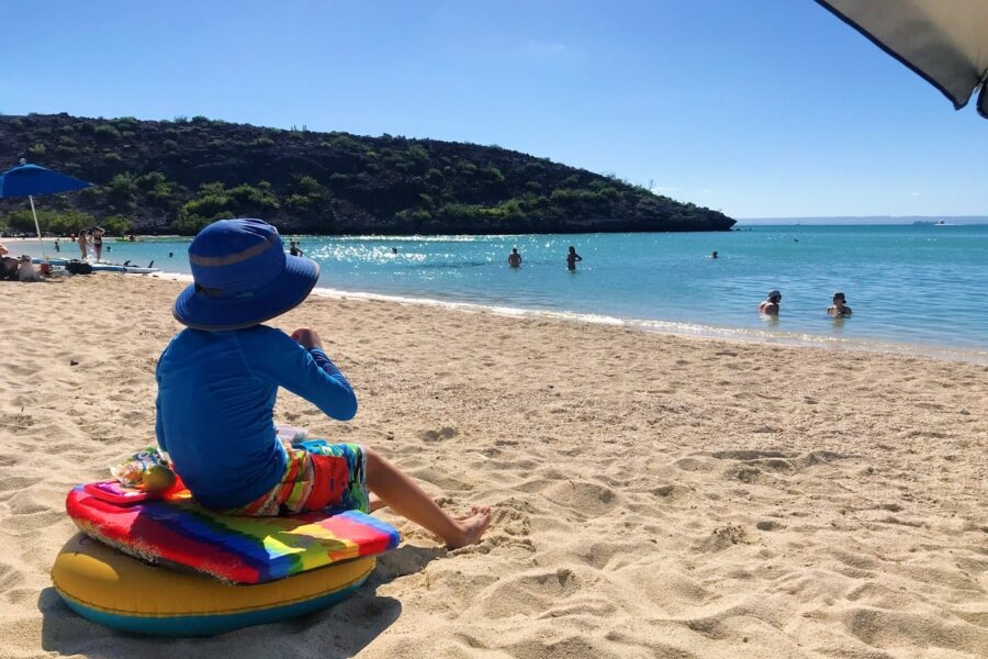 child sitting on beach in Mexico