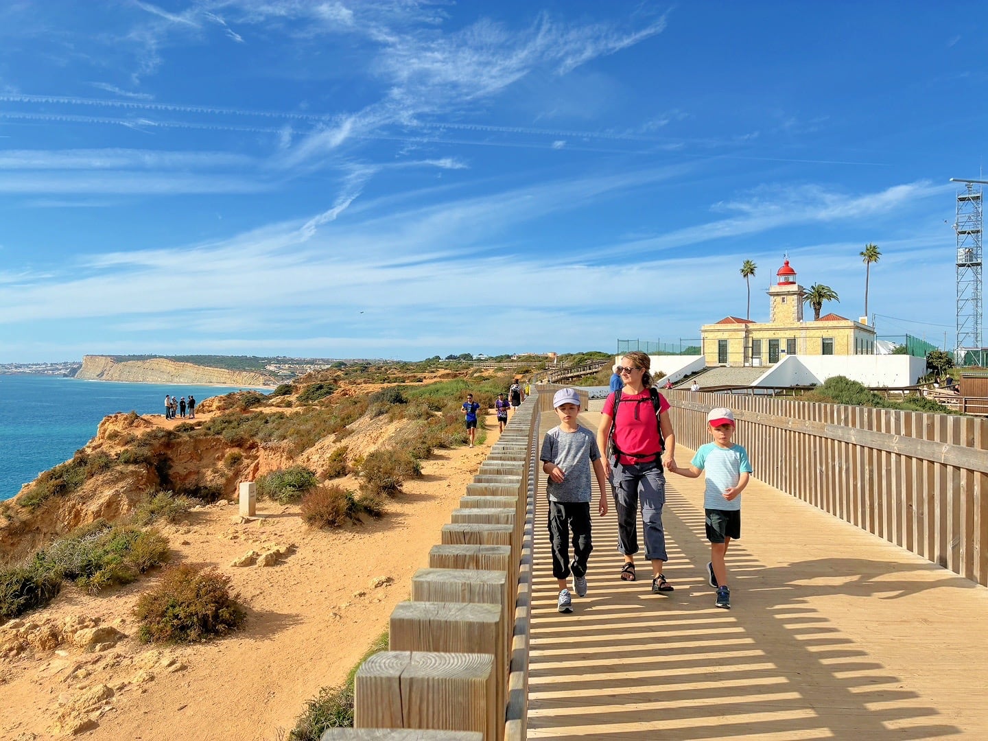 people walking in front of lighthouse